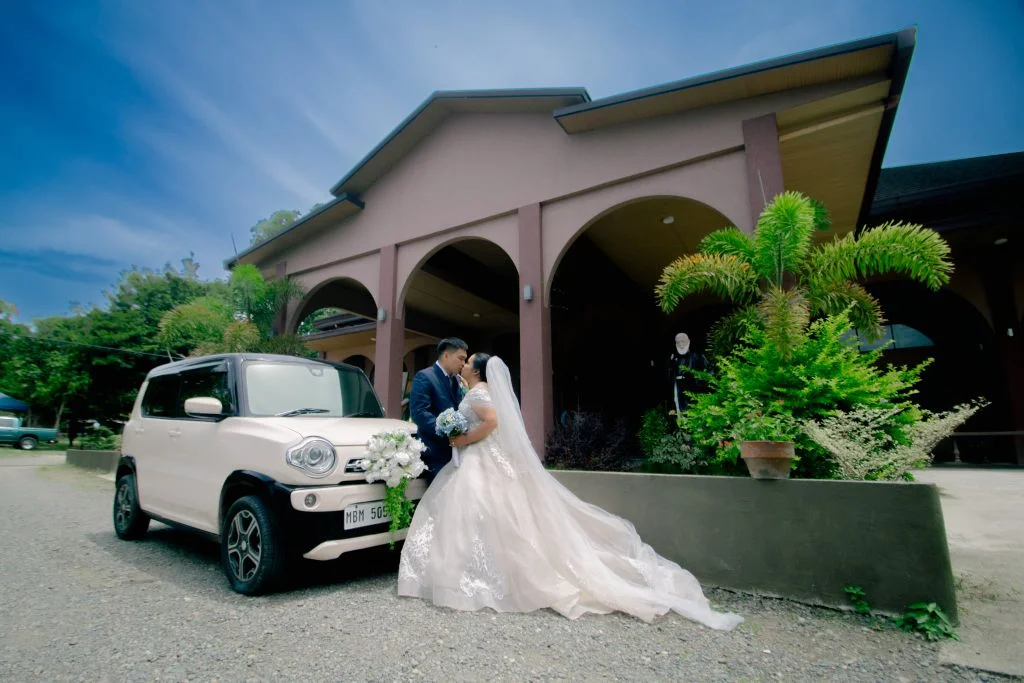 bride and groom just married with car background